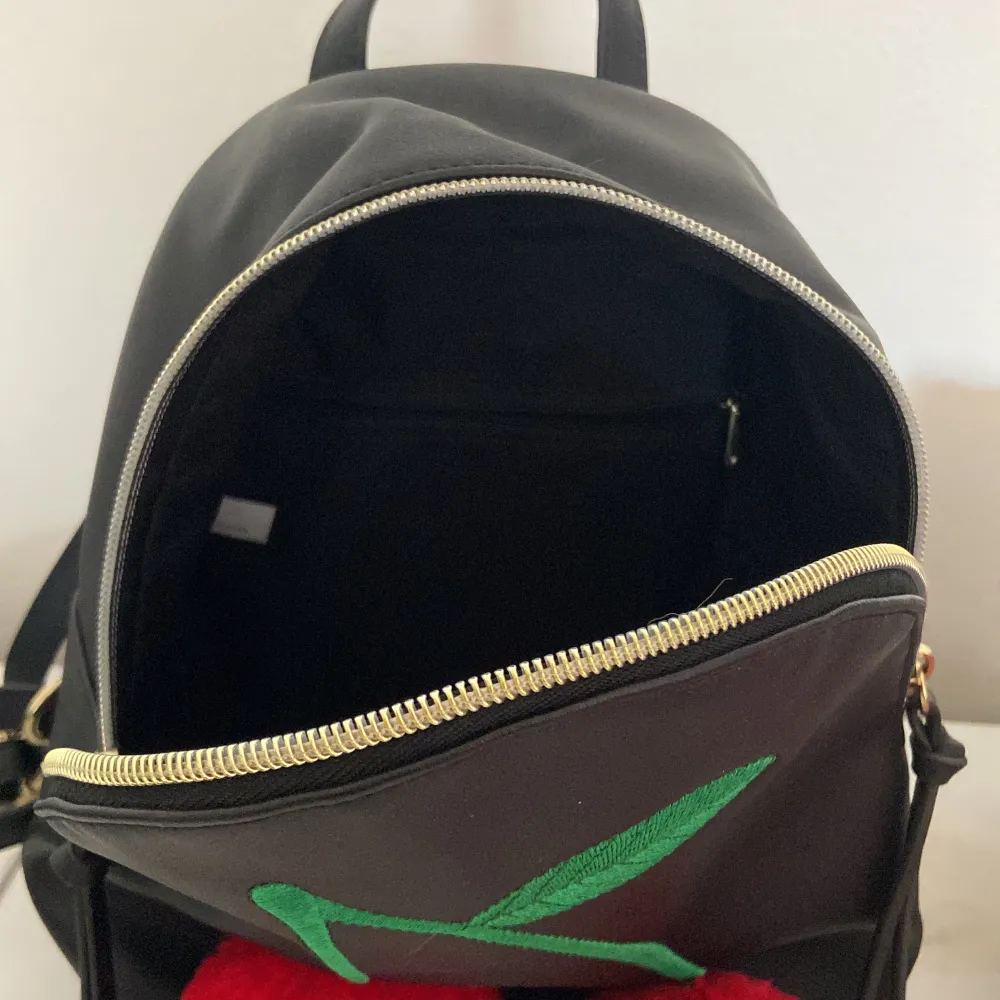 Jättegullig ryggsäck med körsbär på! Rymlig och aldrig använd.   Cirka 22 cm hög och 19 cm bred . Väskor.