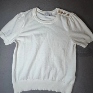 Vit topp - En vit topp med jättesöta guld detaljer som är köpt utomlands☺️ den är använd runt 3 gånger 