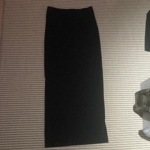 Svart långkjol  - Svart långkjol med en slits bak, jag är 165 och den är hela vägen ner till fötterna. Aldrig använd🤍