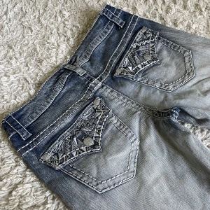 Miss Me liknande jeans - Miss Me liknande jeans från Paisley Sky. ❤️ Midjemått rakt över: 39cm, innerbenslängd: 80cm. Jag är 165cm lång, kan fixa fler mått! Lågmidjad och bootcut modell med snygga detaljer. 🫶 Håll koll på min profil, lägger för det mesta upp vintage jeans! 😍