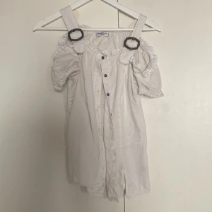Vit blus med spännen - En söt blus, ok skick, lite urtvättad