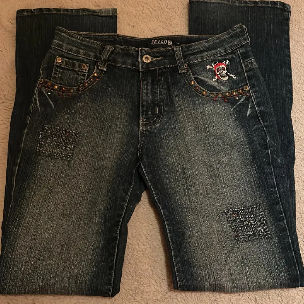 Säljer dessa as balla jeans som är lågmidjade och bootcut från Seyoo, vissa av stenarna har lossnat med det är inget som syns! Midjemått: 79cm  Innerbenslängd: 78cm . Jeans & Byxor.