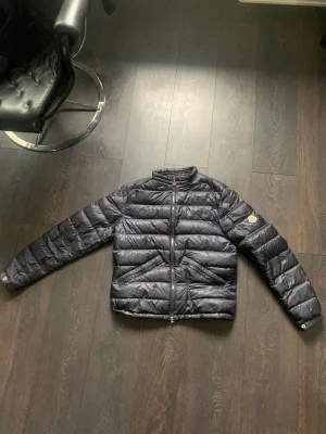 Moncler dunjacka storlek 2 - Hej, säljer nu min strlk 2 moncler jacka i färgen mörkblå då jag växt ut den, skicket är 7 av 10 så därför kan jag tänka mig att gå lågt i pris. Nypriset ligger på ca 8500 kr, ett litet igensytt hål syns på sista bilden, inget man märker irl.