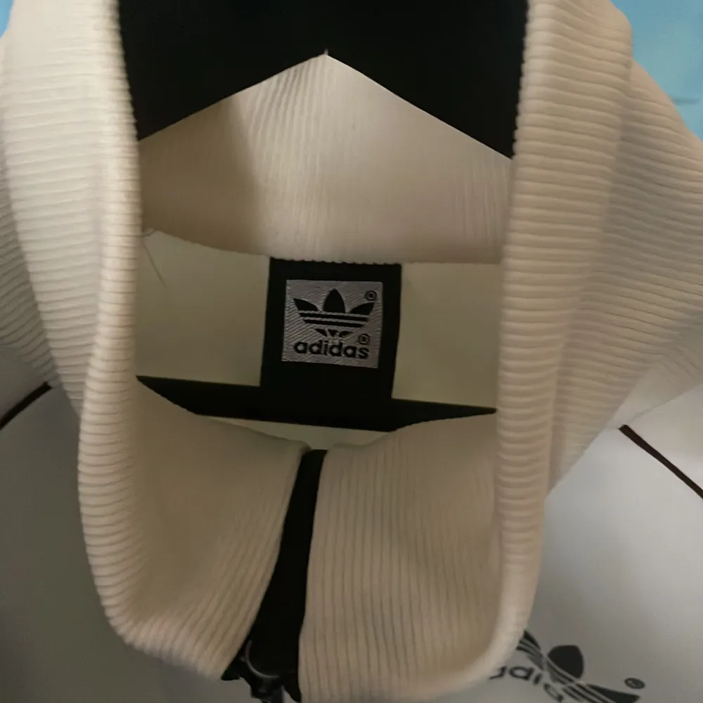 En unik adidas zip up tröja i mycket bra skick. Tröjan är off-white med bruna detaljer och har två st fickor på framsidan, storlek S. Hoodies.