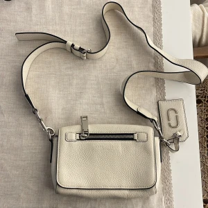 Marc Jacobs väska - Vit Marc Jacobs väska. I bra skick, bara en liten gul fläck på insidan, perfekt skick på utsidan. Kostar 4000 kr ny. 