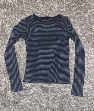 Brandy melville topp - Säljer denna super sköna vit och blå randiga långärmade tröjan från brandy melville då den inte kommer till användning. Nyskick. Det går bra att klicka på köp nu😊.