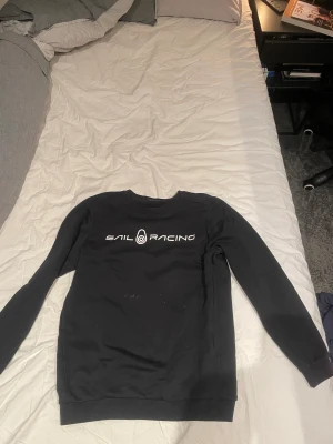 Sail Racing hoodie - En fin svart Sail Racing tröja i storlek 160! Fint skick