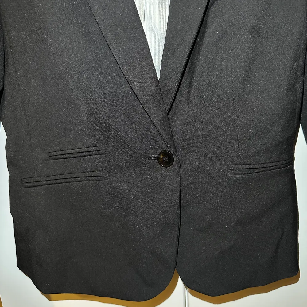 Kort kavaj jacka/blazer från H&M, har även vadderade axlar. Fick av min styvmor men själv endast använd en gång. Fint skick. Säljes då jag aldrig använder & är för liten. Kostymer.