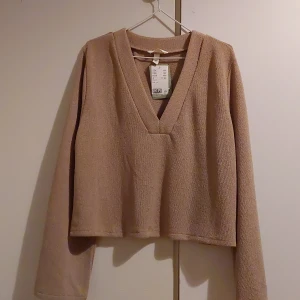 Stickad tröja - Storlek M. Bara testad adrig använd har prislappen kvar. Skön men inte min stil. Den är lite mer ljus beige än på bilden.