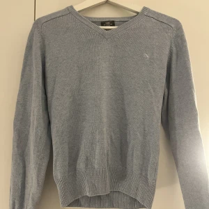 Ljusblå stickad tröja - Ljusblå stickad tröja med v ringning. 