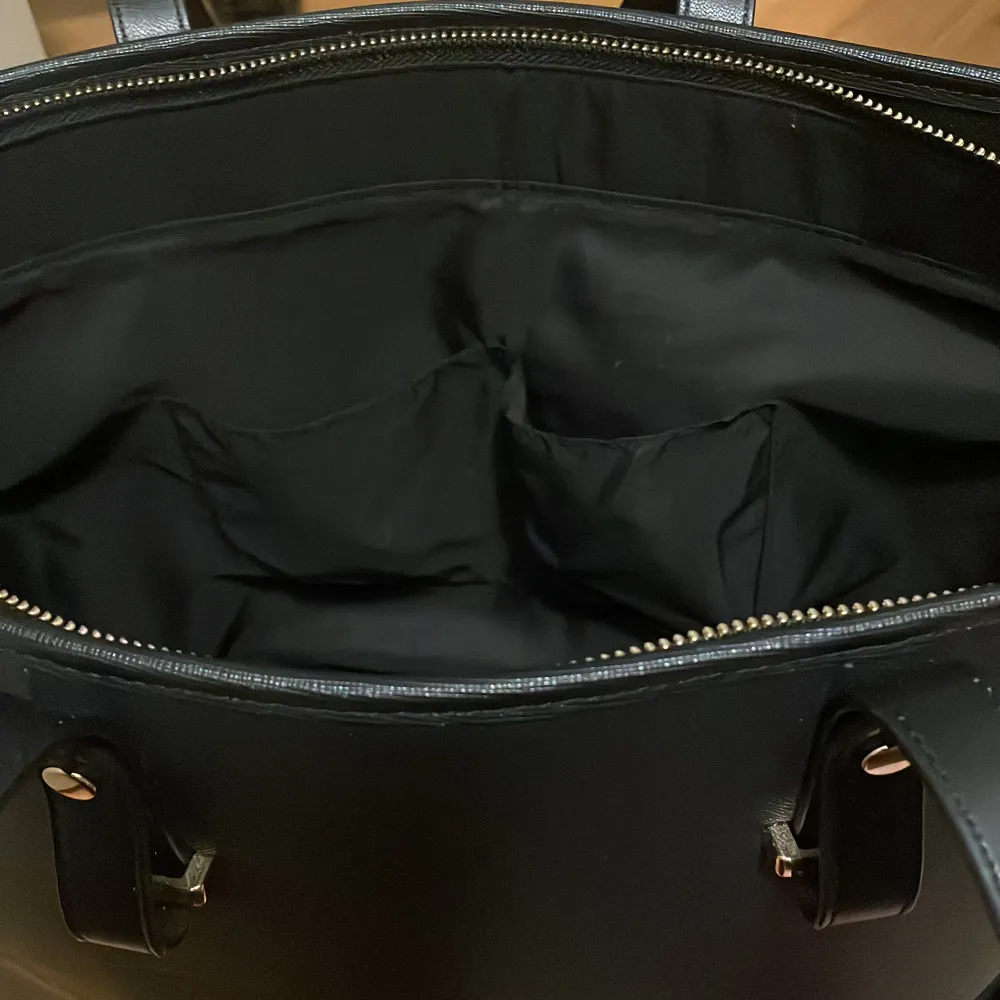 Stor svart handväska från HM med guldig dragkedja. Väskan är i nyskick. . Väskor.