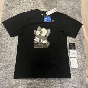 Kaws t shirt  - Säljer en helt oandvänd Kaws t-shirt i storlek S. Den är köpt i On Size i Budapest och kvitto finns. Den kan passa M också. Den har inga skador och allt originellt följer med. Har man några frågor eller vill ha mer bilder är det bara att höra av sig 😁