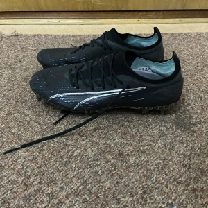 PUMA Ultra Ultimate FG/AG Eclipse  - Fotbollsskor är på bra Skick och har används i 2 månader. Säljer den för att dem har blivit små och har köpt ett par nya. 
