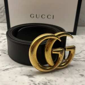 Gucci Bälte 90cm - Säljer mitt fina bruna Gucci Bälte som jag (har för mig) är 90CM. Bältet är inköpt på Gucci Stockholm och Kvitto samt box medföljer såklart! Bältet är lite defekt på GG loggan men inget man tänker på i verkligheten, Syns bara extra i ljuset på bilden!
