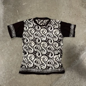 Tshirt med coolt mönster - Mörkbrun T-shirt med coola mönster. Storlek M