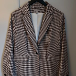 Kavaj  - Perfekt höstkavaj i nyskick. Vinröd/offwhite hundtandsmönstrad.  Detaljer som 3 knappar på ärmen. 