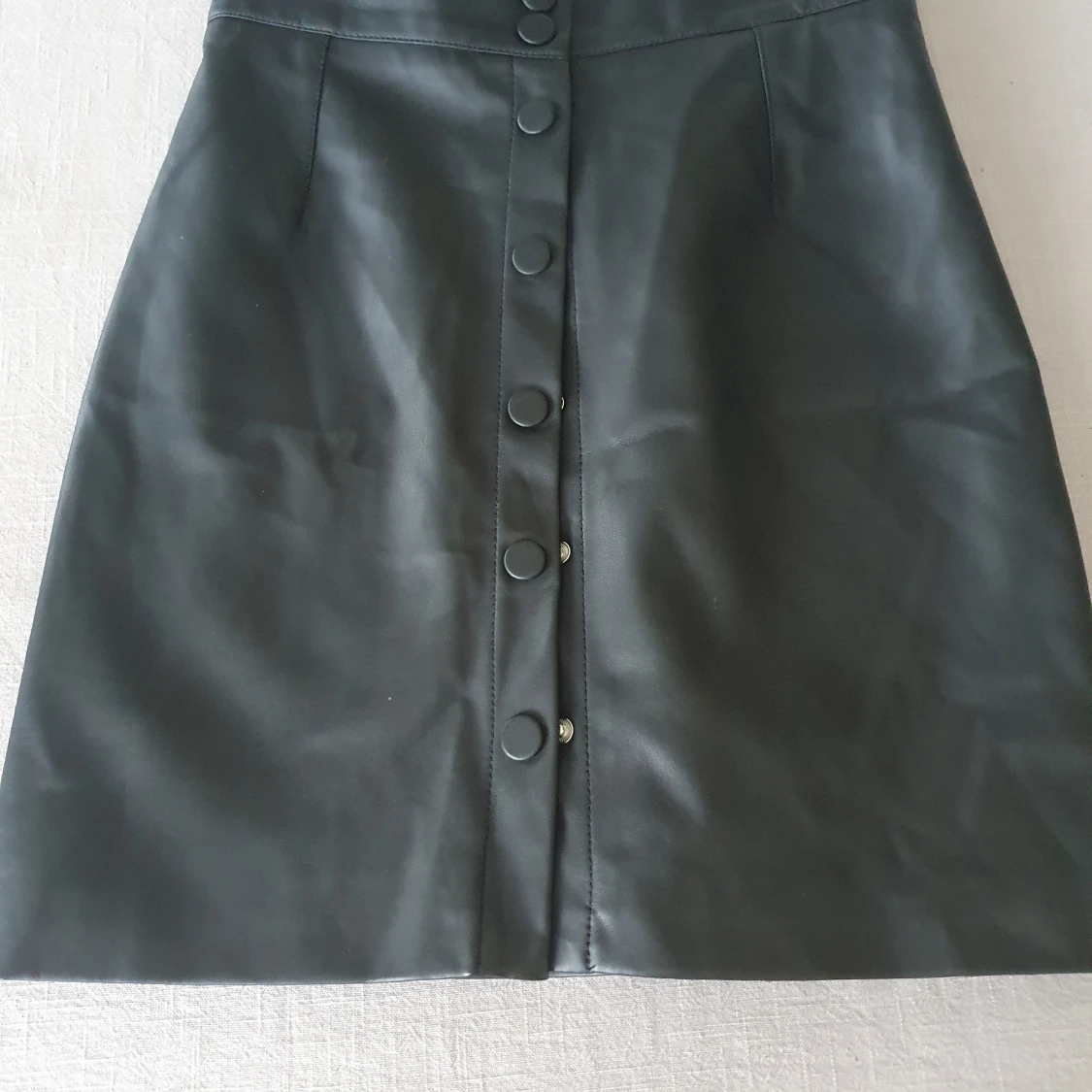 Svart kjol i skinnimitation.