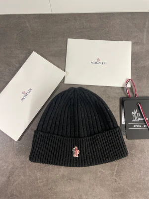 Moncler Mössa - Säljer denna feta Moncler Grenoble mössa, den är i bra skick! Och kommer med de moncler grejerna som syns på bilderna! 