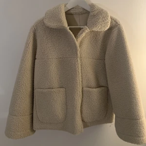 Teddyjacka YAS - Beige Teddyjacka från märket YAS i storlek M. Jackan går att använda på två sätt (går att vända ut och in och använda så). Mycket bra skick! Knappt använd. 