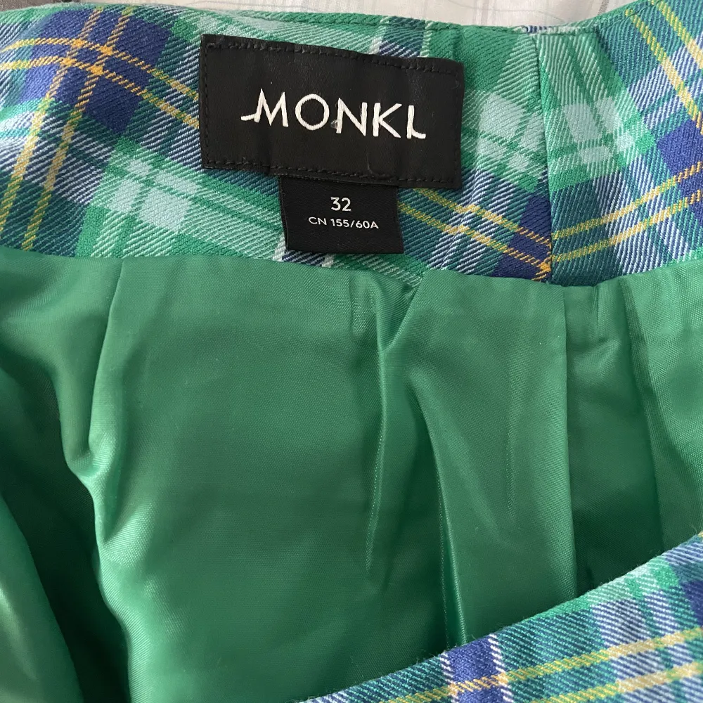 Rutig pennkjol i grönt från Monki, i storlek 32. Använd en gång. Stretchigt tyg som passar XXS/XS/S. . Kjolar.