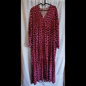Klänning  - Klänning, cerise, leopardmönstrad från "Love forever", Italien. Ord pris ca 900 kr. Använd 1 gång. Stl S men mer som en L. 