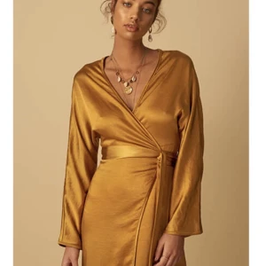 Klänning från Adoore - Säljer denna klänning i omlott från Adoore som är från en av deras första kollektion. Helt ny med lappar kvar! 