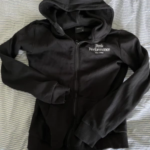 Peak performance zip - Ziphoodie från peak performance, fåtal gånger använd så den är i fint skick , storlek 170 men passar mig som har xs/s i vanliga fall (nypris 800kr)