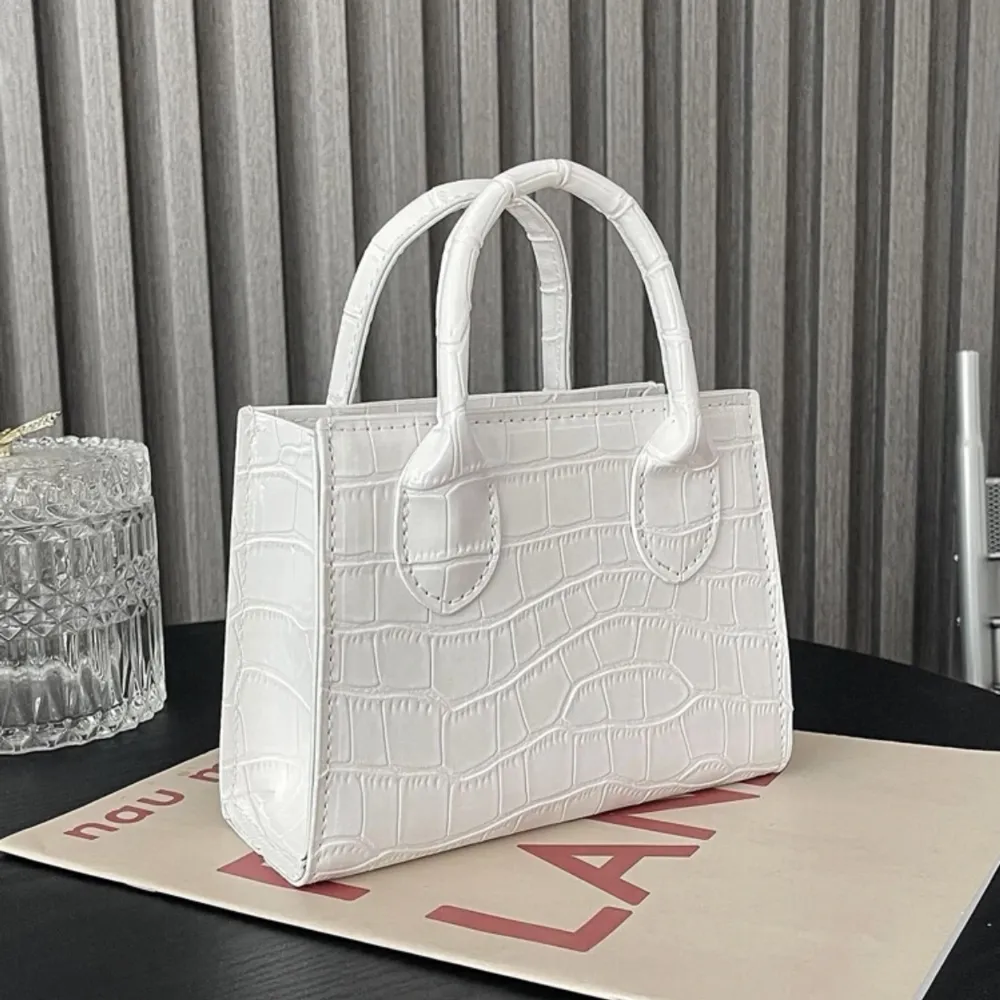 Jätte söt vit liten handväska! Köpt för länge sedan men faktiskt helt oanvänd.  Mått: 13cm hög 17cm lång. Väskor.