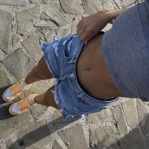 Blåa jeansshorts  - Blåa jeans shorts me slitningar, (lånad bild)