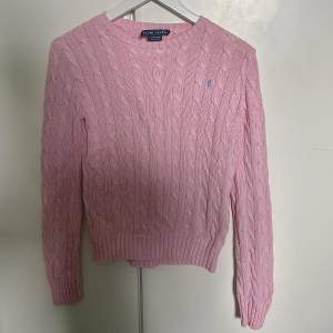En rosa tröja från Ralph Lauren i mycket bra skick bortsett från att etiketten sitter löst i ena änden.