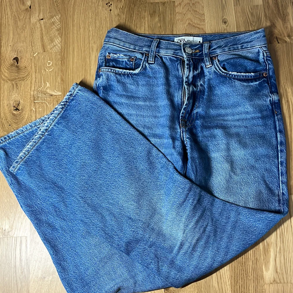Midwaist/lågmidjade Zara jeans med bootcut. Använda men i fint skick utöver små slitningar längst nertill på byxorna samt lite smutsiga (syns på sista bilden) därav priset. Storlek: 34 Midjemått: 72 Innerbenslängd: 72 cm. Jeans & Byxor.
