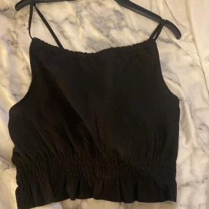 Blus - En jätte fin top från Gina! Aldrig använd, prislappen finns kvar. Öppen i ryggen. Det står att det är XL i storlek men tycker den borde vara i M/L