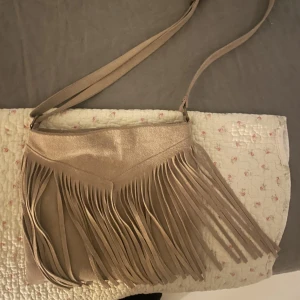 Superfin mocka väska🥰 - Super fin väska! Beige grå väska med fransar! Super bra skick, använd fåtal gånger.🥰