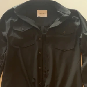 Overshirt - Svart övershirt i helt nytt skick, aldrig använd från shaping new tomorrow. Nypris 1,300.