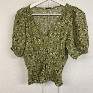 Blommig blus - Fint skick, främjar midja. Skönt o luftigt tyg