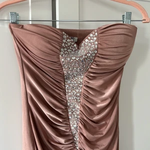 Festklänning gammeldagsrosa - Festklänning i en rosa/ gammeldagsrosa färg. Oanvänd och jätte fin.   Storlek xs. 