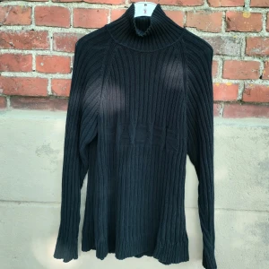 Svart Racer turtleneck - Svart tröja ifrån märket Racer med otroligt snygg konstruktion. Tröjan är helt slutsåld men kostade 900kr+ ny. Den är stretchig och rätt lång vilket gör att den både passar som snyggt vardagsplagg eller som mysig hemmatröja. Väldigt bra kvalite och skick!