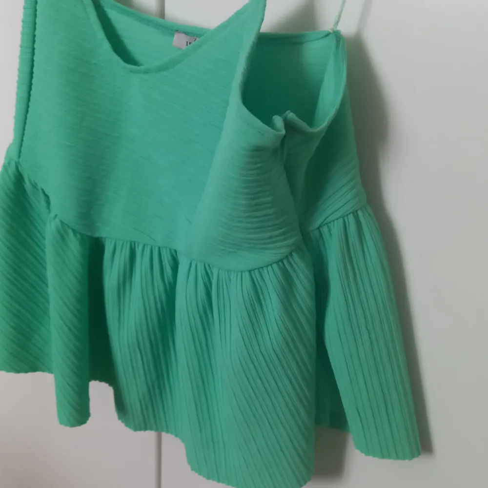 Green, short top with a zipper on the other side. . Toppar.