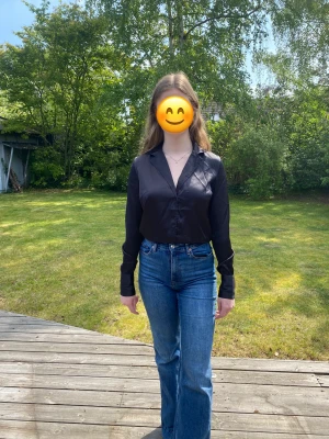Svart skjort-blus - Svart skjort-blus i ett glansigt material med resår nertill (se sista bild), ursprungligen från NAKD, Misslisibells kollektion