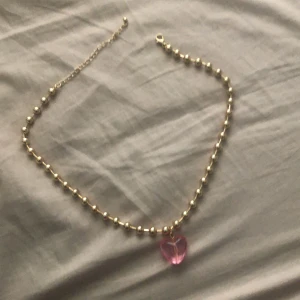Hjärt halsband - Det här halsbandet är i bra size och har ett rosa hjärta på botten