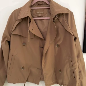 Kort trenchcoat - Super fin vår samt trendig jacka som passar till allt. Använd fåtal och det finns inga fel på den. Jag säljer den för att den blev för liten för mig. Storleken på den är 38 men passformen är liten så skulle säga att den är mer åt 36 hållet enligt mig.  