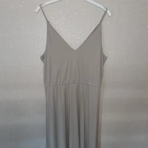 Beige klänning - Säljer min beiga klänning, den ser grå ut på bilderna men den är mer beig i verkligheten, väldigt skön!💘(Köparen står för frakt)