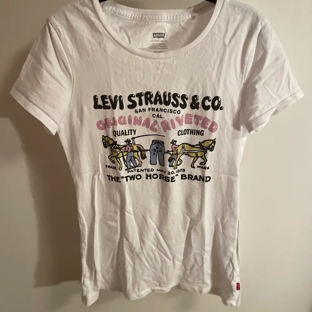 Vit Levis T-shirt med snyggt unikt tryck där fram🌆 Den sitter ganska tight i modellen💗. T-shirts.