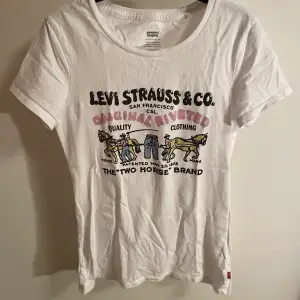 Vit Levis T-shirt med snyggt unikt tryck där fram🌆 Den sitter ganska tight i modellen💗