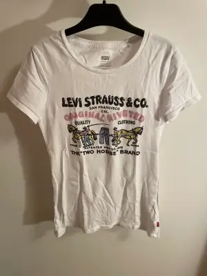 Vit Levis T-shirt med snyggt unikt tryck där fram🌆 Den sitter ganska tight i modellen💗