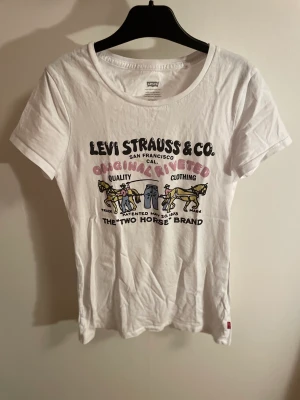 Levis T-shirt  - Vit Levis T-shirt med snyggt unikt tryck där fram🌆 Den sitter ganska tight i modellen💗