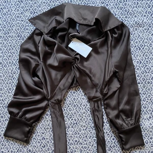 Blus  - En jättefin blus i mörk brun  Storlek ONE SIZE  Jag bär oftast XS/S  Köptes på Missay för 259kr  Aldrig använt, lappen sitter fortfarande kvar 