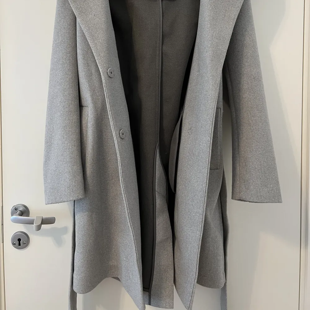 Mycket fin grå kappa med luva. Använt endast 1 gång. Storlek 38 men passar perfekt för mindre storlekar också.. Jackor.