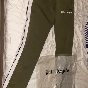 Palm Angels trackpants - Palm Angels trackpants i military green. Storlek S , kan tänka mig att gå ner i pris vid snabb och smidig affär. Tags och påse finns till byxorna. 