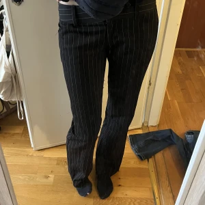 Lågmidjade kostymbyxor  - Ett par lågmidjade svart vit randiga kostymbyxor. Bra i längden på mig som är 170. Lite trådiga men annars i bra skick. Skriv om ni vill ha fler bilder eller undrar något. Skriv gärna innan till mig innan du köper 💕
